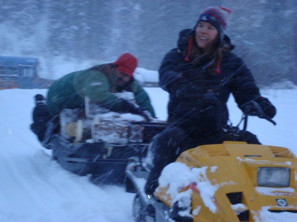 Jenny and Bob bringing wood on a snow machine